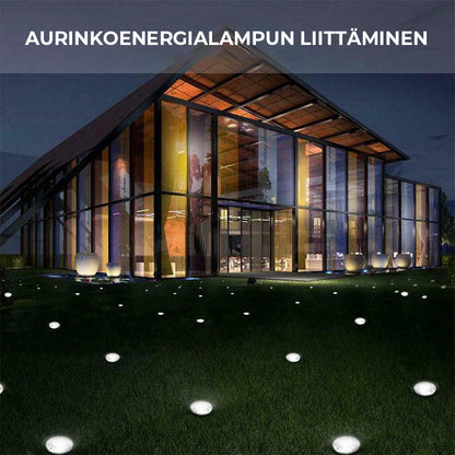 "Aurinkoenergialla toimivat LED-polkuvalot puutarhaan, hopeinen runko, lämpimän valkoiset LEDit, istutettuna nurmikolle."