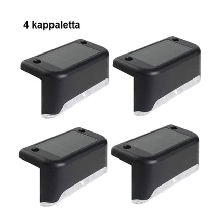 "Aurinkovoimainen musta terassivalo, lämmintä sävyä, vesitiivis, moderni muotoilu ulkokäyttöön."